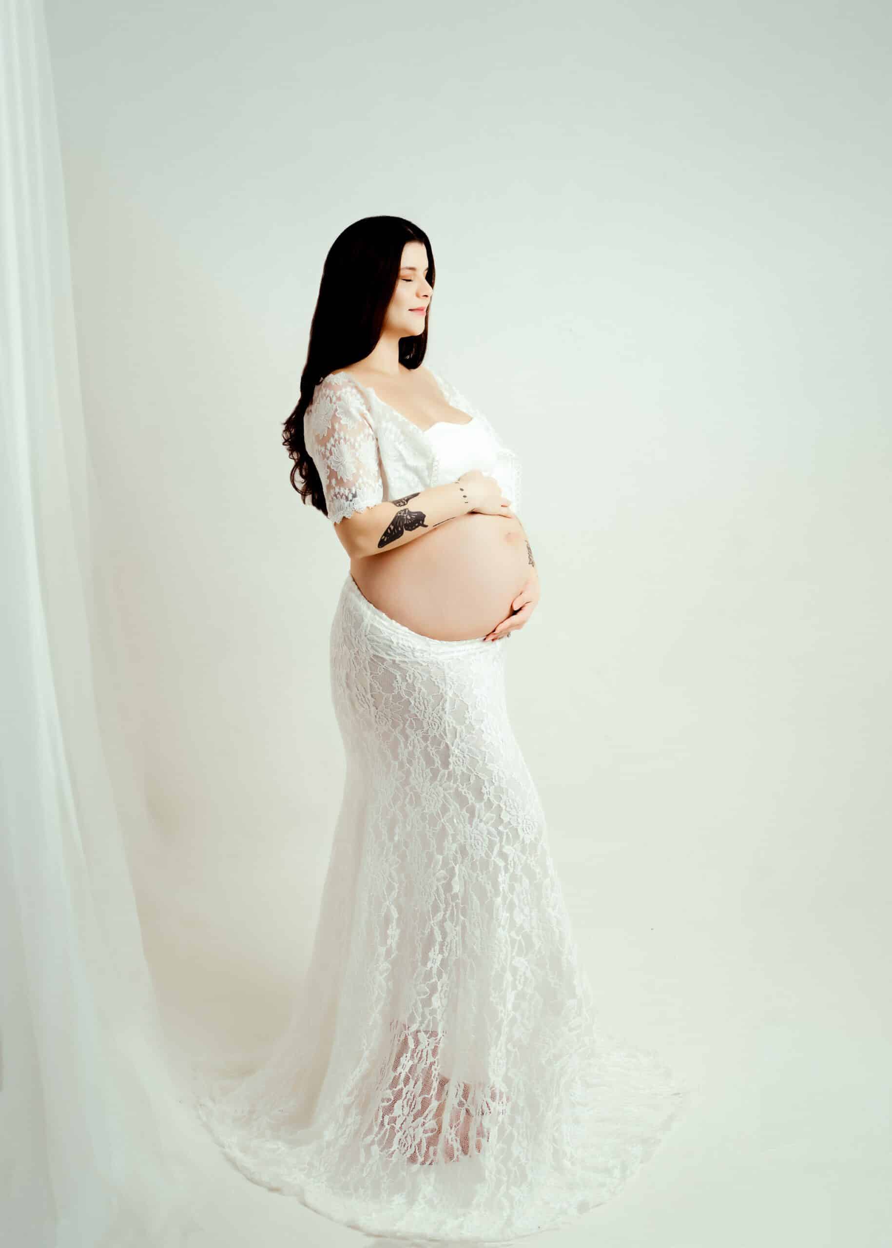 "Serene white maternity session featuring a peaceful expectant mother in a clean and bright setting, highlighting the purity and tranquility of this special moment
